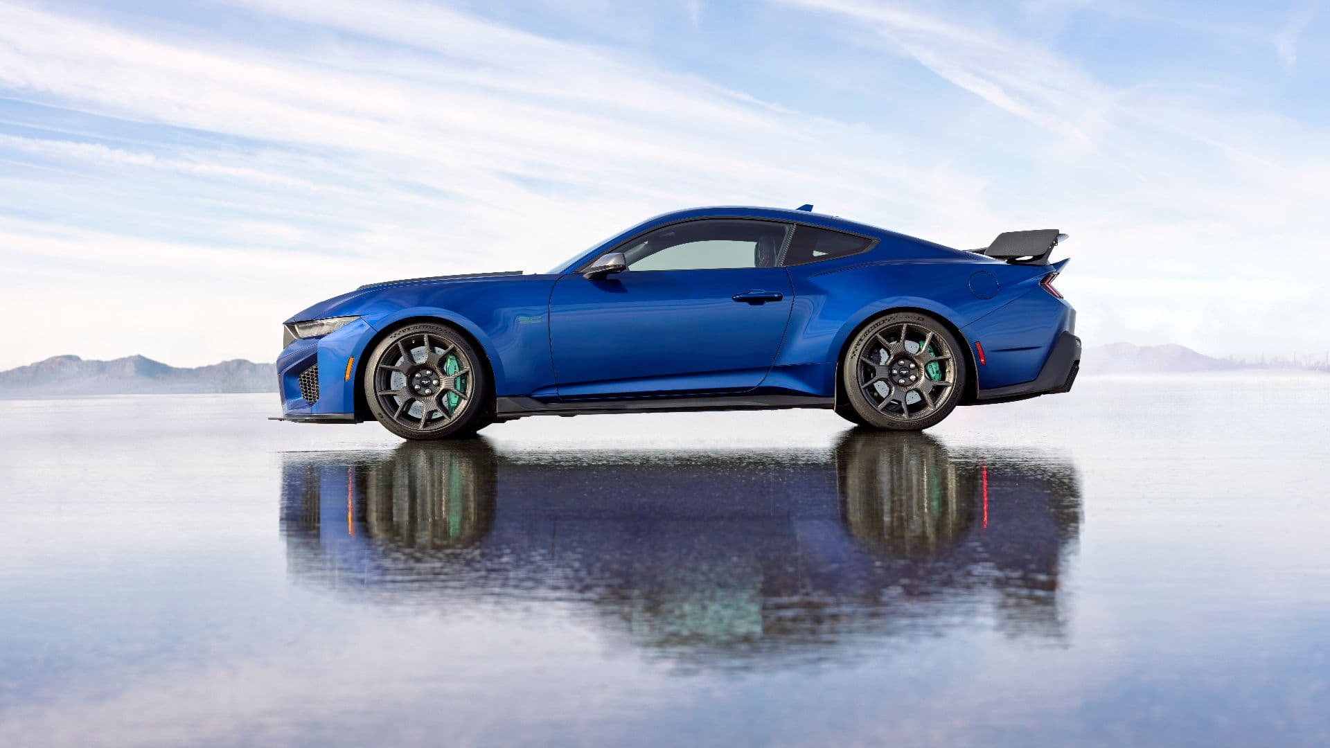 Side profile of the Dark Horse SC Track Pack in Adriatic Blue, showing the carbon-ceramic brakes and rear wing.